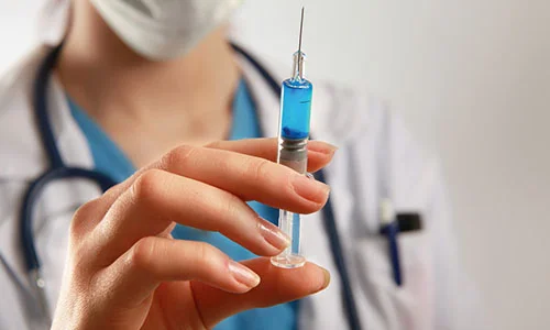врач держит шприц